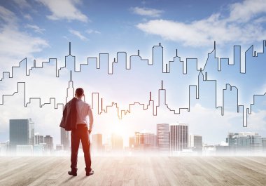 İşadamı arkasını dönüp modern iş merkezinin siluetine bakıyor.