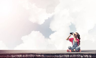 Dürbünle bakan, okul çağındaki sevimli kız çatıyı inşa ediyor.