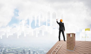 Mühendis adam evin çatısında ayakta 