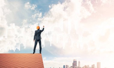 Mühendis adam evin çatısında ayakta 