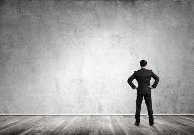 Boş beton odada kendine güvenen zarif iş adamının arka planı