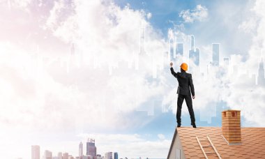 Mühendis adam evin çatısında ayakta 