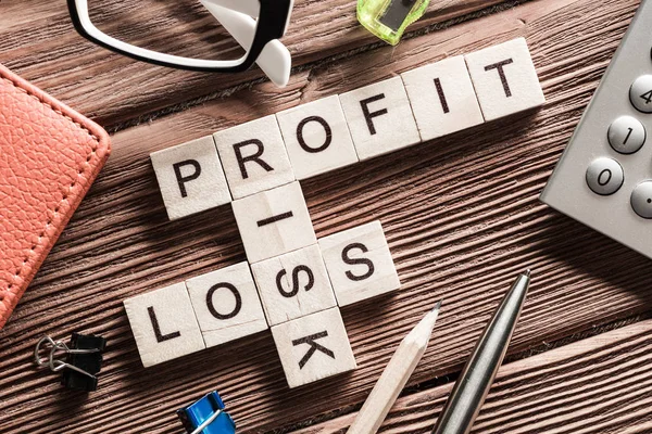 Profit loss and risk words on workplace collected of wooden cubes