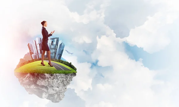 Businesswoman standing on green floating island — Stock Photo, Image