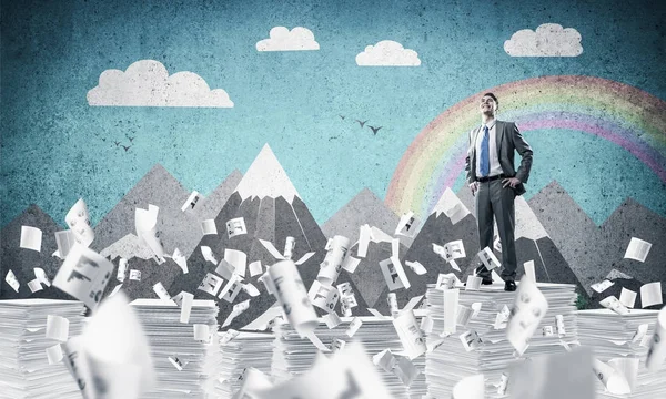 Businessman in suit standing on pile of documents — Stock Photo, Image