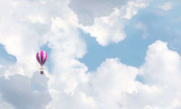 Красочный аэростат летит над голубым облачным небом
. 
