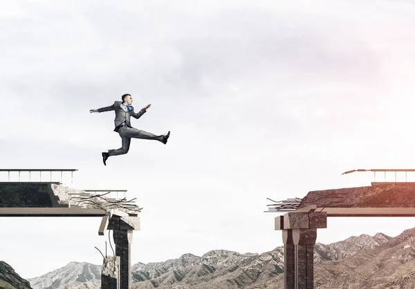 Empresário saltando sobre enorme lacuna — Fotografia de Stock