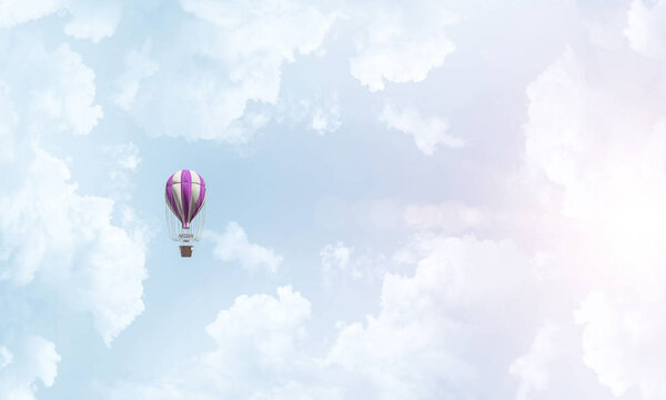 Красочный аэростат летит над голубым облачным небом
.