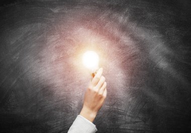 Arka plan grunge duvarında parlayan parlak lamba olan insan eli. Profesyonel iş yardımı ve danışmanlık hizmeti. Elektrik ampulü ile başarılı çözüm iş motivasyonu.