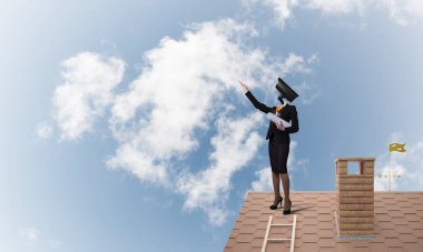 Evin çatısında baş durmak yerine kamerayla zum yapan yüzsüz iş kadını.