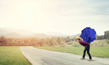 Sırtında kağıt top taşıyan inşaatçı.