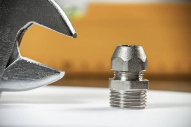 Boru hattı elementi ve ayarlanabilir anahtar masanın üzerinde. Çelik su tesisatları ve hidrolik sistem bağlantıları. Banyo tamiri veya inşaat hizmetleri için yeni ekipman.