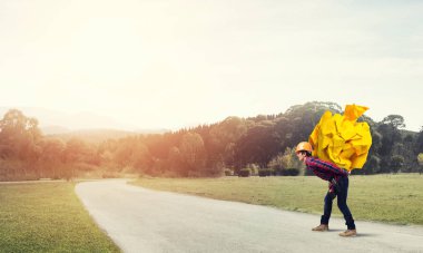 Sırtında kağıt top taşıyan inşaatçı.