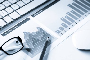 Klavye fareli iş yeri ve grafik ve diyagramlı kağıtlar