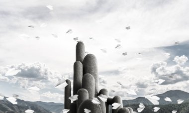 Açık havada, arka planda güzel manzarası olan uçan kağıt uçaklar arasında yer alan yüksek ve büyük taş sütunların resmi. Duvar kağıdı, telif alanı olan arkaplan.