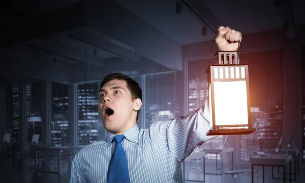 Ein Entsetzter Geschäftsmann Hält Eine Leuchtende Laterne Hintergrund Des Büroinnenraums — Stockfoto