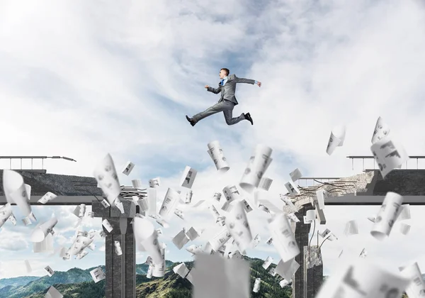 Empresario Saltando Sobre Brecha Puente Entre Los Papeles Voladores Como — Foto de Stock