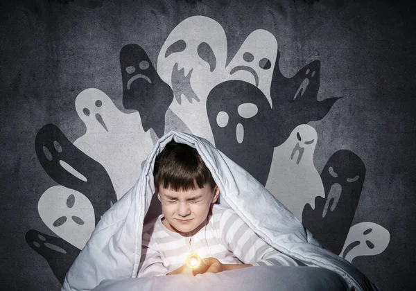 아래에 손전등으로 집에서 침대에 무서워하는 잠옷입은 소년은 없습니다 할로윈 무서운 — 스톡 사진