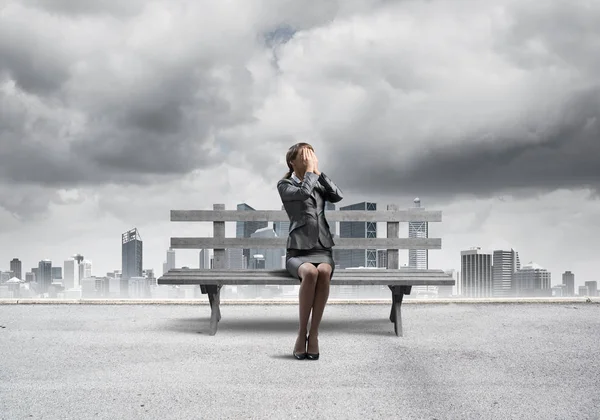 Jeune femme assise sur un banc en bois à l'extérieur — Photo