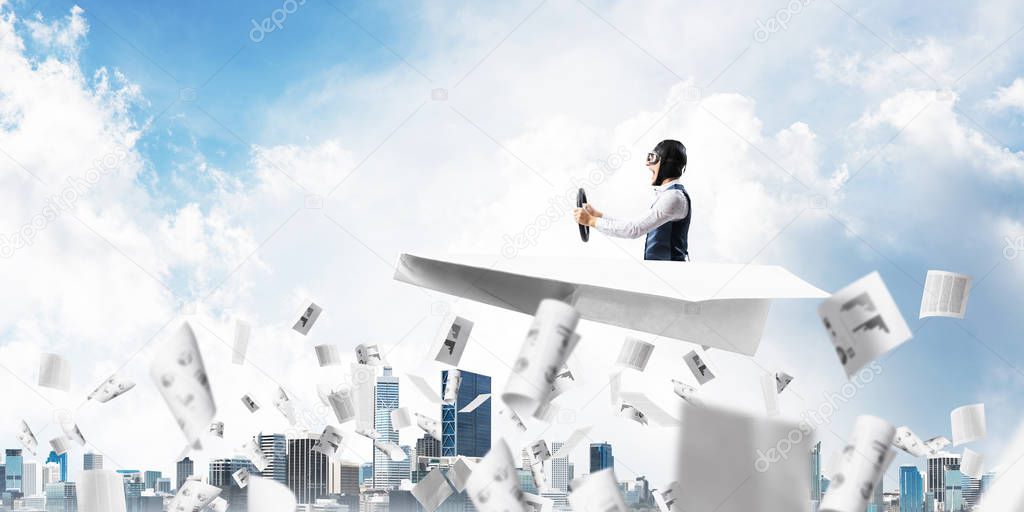 Creative business process concept with funny pilot in leather helmet. Aviator driving big paper plane above falling paper sheets with business infographics. Working with financial documents.