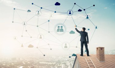 Delikanlı çatıda dikiliyor ve bağlantı hatları çiziyor. Karışık ortam