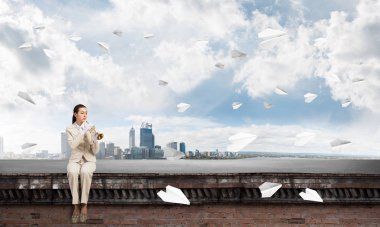 Çekici genç bir kadın binanın çatısında müzik çalıyor. Trompet çalan cesur iş kadını çatının kenarında oturuyor. Mavi gökyüzünde uçan kağıt uçaklar. Modern şehrin çatısında müzik gösterisi