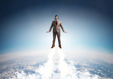 Mavi gökyüzünde süper kahraman olarak uçan takım elbiseli ve havacı şapkalı bir iş adamı. Süpermen olarak şirket yöneticisi stratosferde jet aleviyle yukarı doğru fırlatılıyor. Başarılı iş kurma motivasyon kavramı