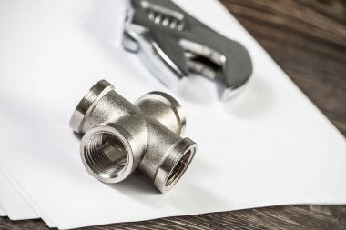 Boru hattı elementi ve ayarlanabilir anahtar masanın üzerinde. Çelik su tesisatları ve hidrolik sistem bağlantıları. Banyo tamiri veya inşaat hizmetleri için yeni ekipman.