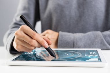 Proje yönetimi için tablet bilgisayar kullanan bir kadın. Kalemi tutan ve tablet cihazına dokunan kadının yakın çekimi. Çevrimiçi borsa ve yatırım. İş hayatında mobil akıllı aygıt