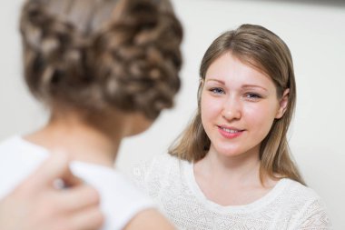 Çocuğu muayene eden doktor ve hastanede steteskopla akciğeri dinle. Küçük kızın tıbbi muayenesi. Gülümseyen genç anne ve küçük kız düzenli pediatrik muayenede. Aile Sağlık Merkezi