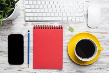 En iyi görünüm ofis yöneticisi çalışma alanı. Bilgisayar klavyesi, cep telefonu, kahve ve spiral dizüstü bilgisayar ile düz yatıyordu ahşap masa. Zaman yönetimi ve günlük planlama. İş dünyasında modern dijital teknoloji