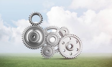 Yeşil çayır üzerinde dişli tekerlekler ile soyut mekanizma