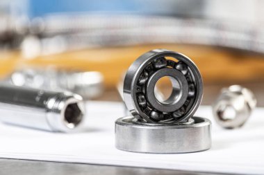 Boru hattı ve bilyeler masanın üzerinde duruyor. Su tesisatları ve örgülü hortum parçaları. Motor mekanizmaları için çelik detaylar. Ev altyapısı tasarım ve kurulum