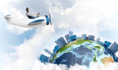 Küçük uçağın kamarasında oturan neşeli genç pilot. Havacı şapkalı, gözlüklü, pervaneli, komik bir adam. Uçakla dünyayı dolaşmak. Dünya küresi bulutlu gökyüzü manzaraları arasında.