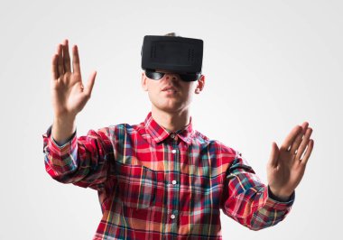 Ekose desenli gömlek gri arka plan karşı sanal kask giymiş genç adam