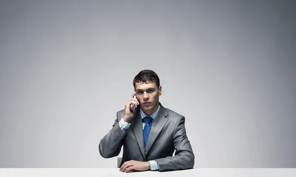 Junger Mann Telefoniert Und Schaut Die Kamera Geschäftsmann Schreibtisch Vor — Stockfoto