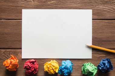 Tahta masadaki beyaz kağıt ve kalemi kapat.