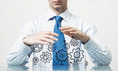 Masada oturan ve dişli mekanizması avuç içi gösterilen işadamı yakın çekim