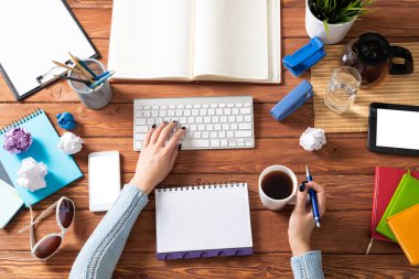 Bilgisayarda çalışan serbest çalışan bir kadın. İş yerinde kahve molası. Çevrimiçi iş eğitimi konsepti. Kadın eli ve klavyesi olan düz bir ofis işyeri. Lawler belgelerle çalışıyor