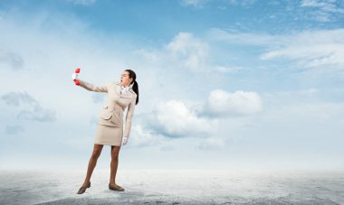 Genç kadın elindeki retro telefona korkmuş gibi görünüyor. Beyaz takım elbiseli, telefonu açık havada duran ürkek sekreter. Yardım hattı destek servisi. İş yardımı ve danışma kavramı