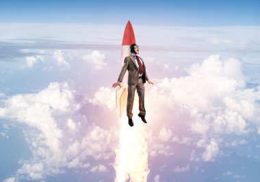 Takım elbiseli ve pilot şapkalı bir işadamı stratosferde roket üzerinde uçuyor. Bulutların üstünde mavi gökyüzünde jetpack roketiyle uçan süper kahraman iş adamı. Başarılı bir iş girişimiydi. Kariyer gelişimi konsepti.