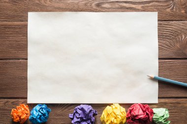 Tahta masadaki beyaz kağıt ve kalemi kapat.