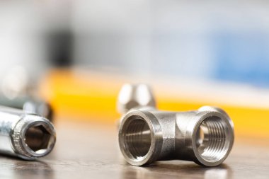 Hidrolik sistem için çelik su bağlantı parçaları ve bağlantıları. Sıhhi tesisat boru hattı yedek parçaları masaya döşeme. Banyo tamiri veya inşaatı için yeni ekipmanlar. Profesyonel sıhhi tesisat teknik servis