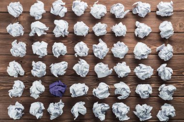 Fikir olarak ahşap masanın üzerine buruşmuş beyaz kağıt parçası.