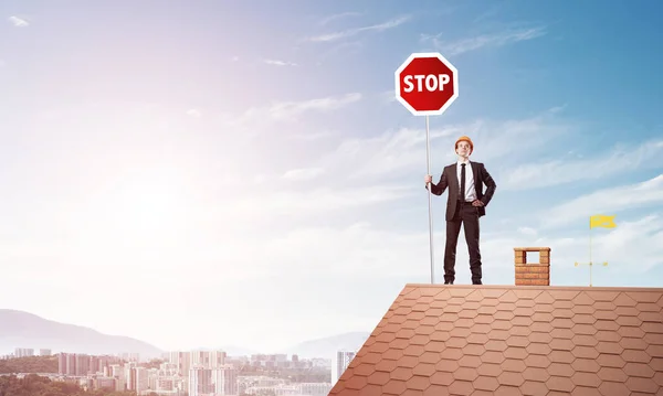 Επιχειρηματίας Στέκεται Πάνω Στέγη Σπιτιού Και Κρατώντας Πινακίδα Stop Μικτή — Φωτογραφία Αρχείου