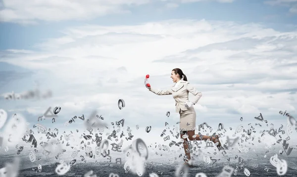 Klasik kırmızı telefonuyla dışarıda koşan bir kadın. Beyaz takım elbiseli çağrı merkezi operatörü telefonla poz veriyor. Telefon hattı pazarlaması ve iletişim. Profesyonel iş yardımı ve desteği