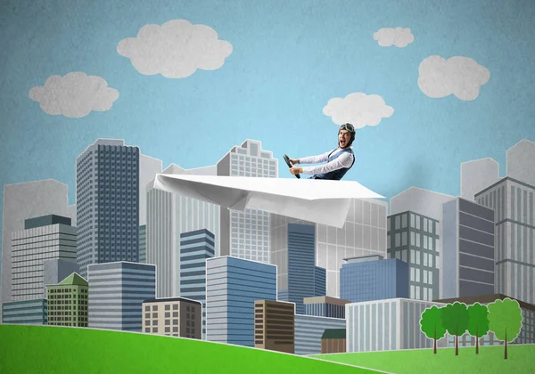 Aircraft pilot flying in paper plane. Aviator driving paper plane on background of city illustration. Cartoon cityscape with high skyscrapers, green grass and trees. Mixed media concept
