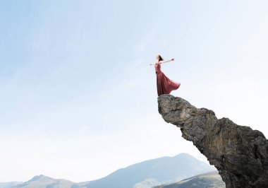 Genç çekici kadın rahatlatıcı yaz gün ayakta rock üstte