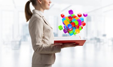 Açık kitabın üzerinde renkli geometrik 3d küp kompozisyonu gösteren bir kadın. Dijital teknoloji ve yenilik çözümleri kavramı. Bulanık ışık arkaplanı üzerine açık kitabı olan iş kadını.