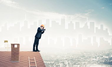 Takım elbiseli ve miğferli genç işadamı yeni bir şey arıyor. Karışık ortam